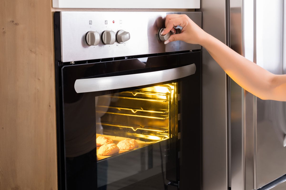 woman baking oven adjust setting lever timer