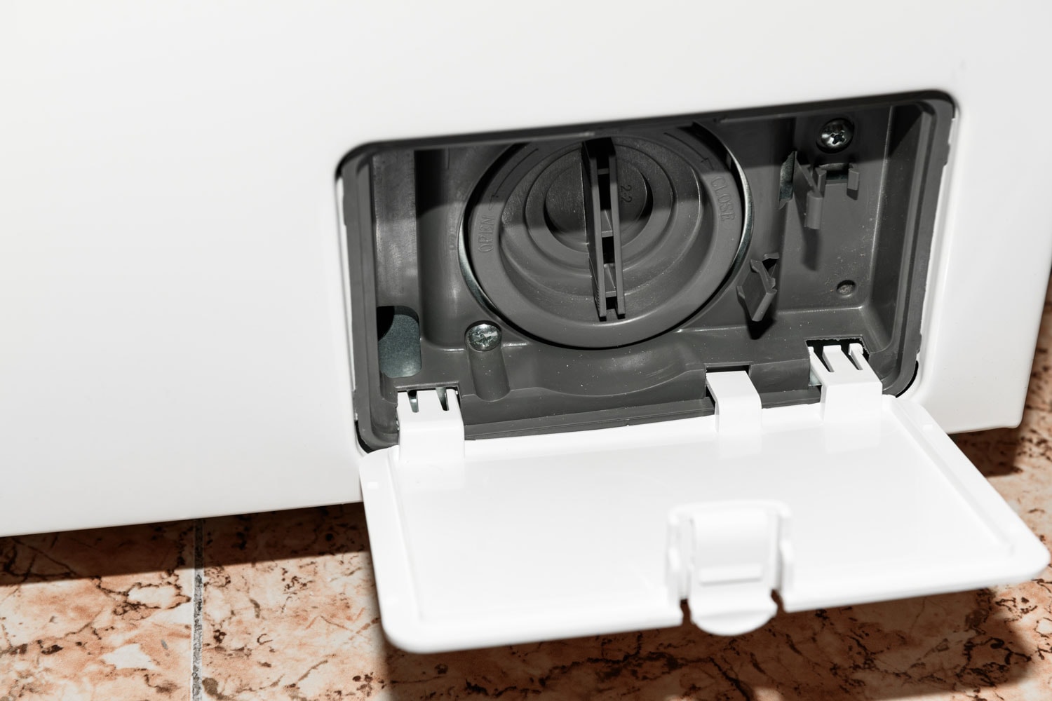 洗衣机排水干净,特写。打开滤波器的封面洗衣机